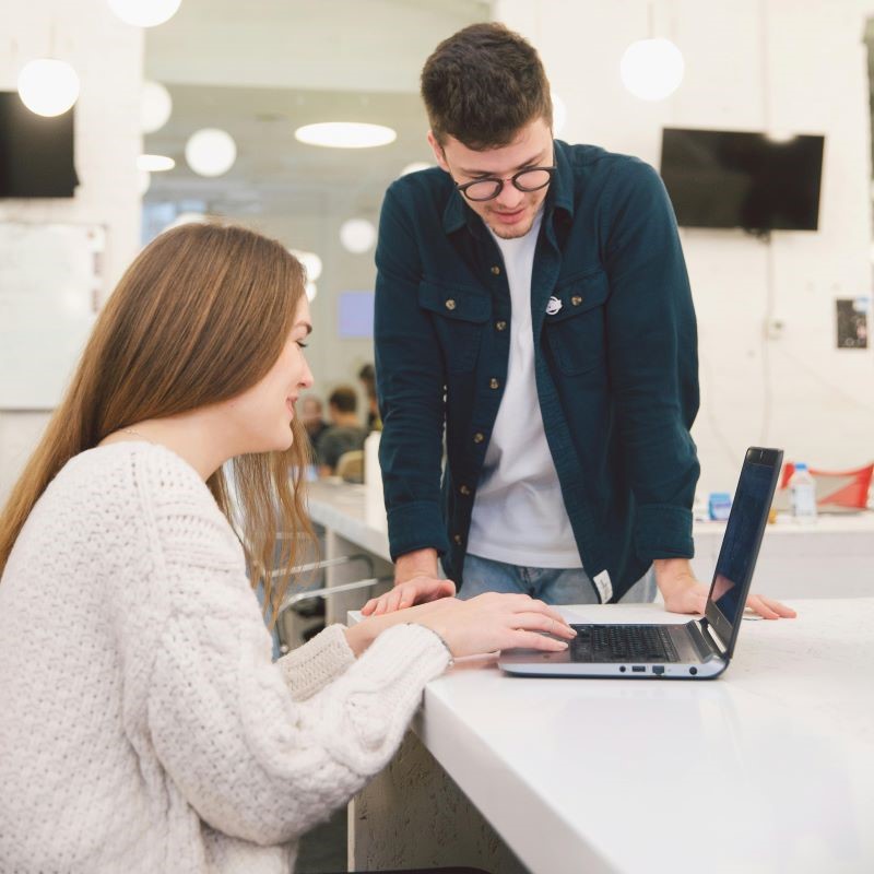 Modernes Büro mit Mitarbeitern, die an flexiblen Arbeitsplätzen kollaborieren.