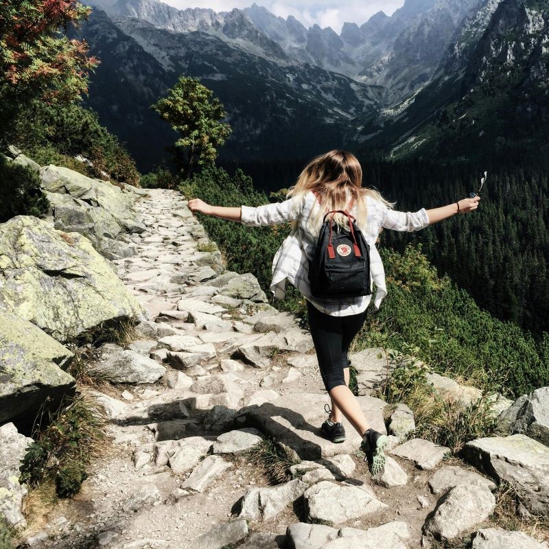 Person meditiert auf einem Felsen mit Blick auf Berge