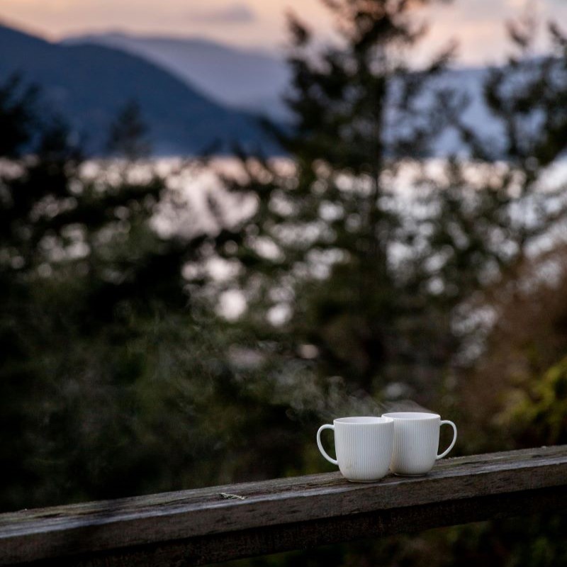 Eine Kaffeetasse vor einer atemberaubenden Bergkulisse