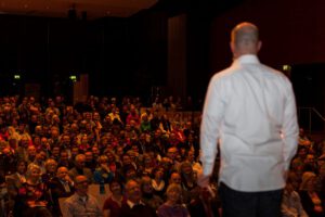 Nils Bäumer, Keynote Speaker und Experte für Kreativität und KI, spricht vor einem großen Publikum